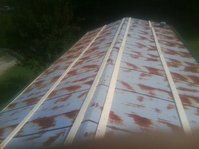Rusted metal roof panels with new wood purlins before replacement — Storm Damage Roof Repair in Leggett by Roofing Brothers
