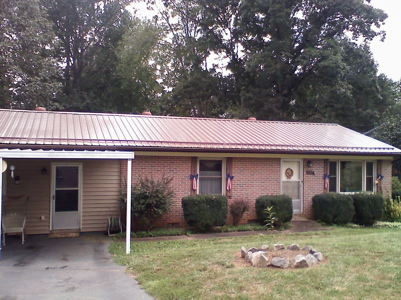Bronze metal roof and carport on a brick ranch home — Roof Repair work by our crew in Leggett